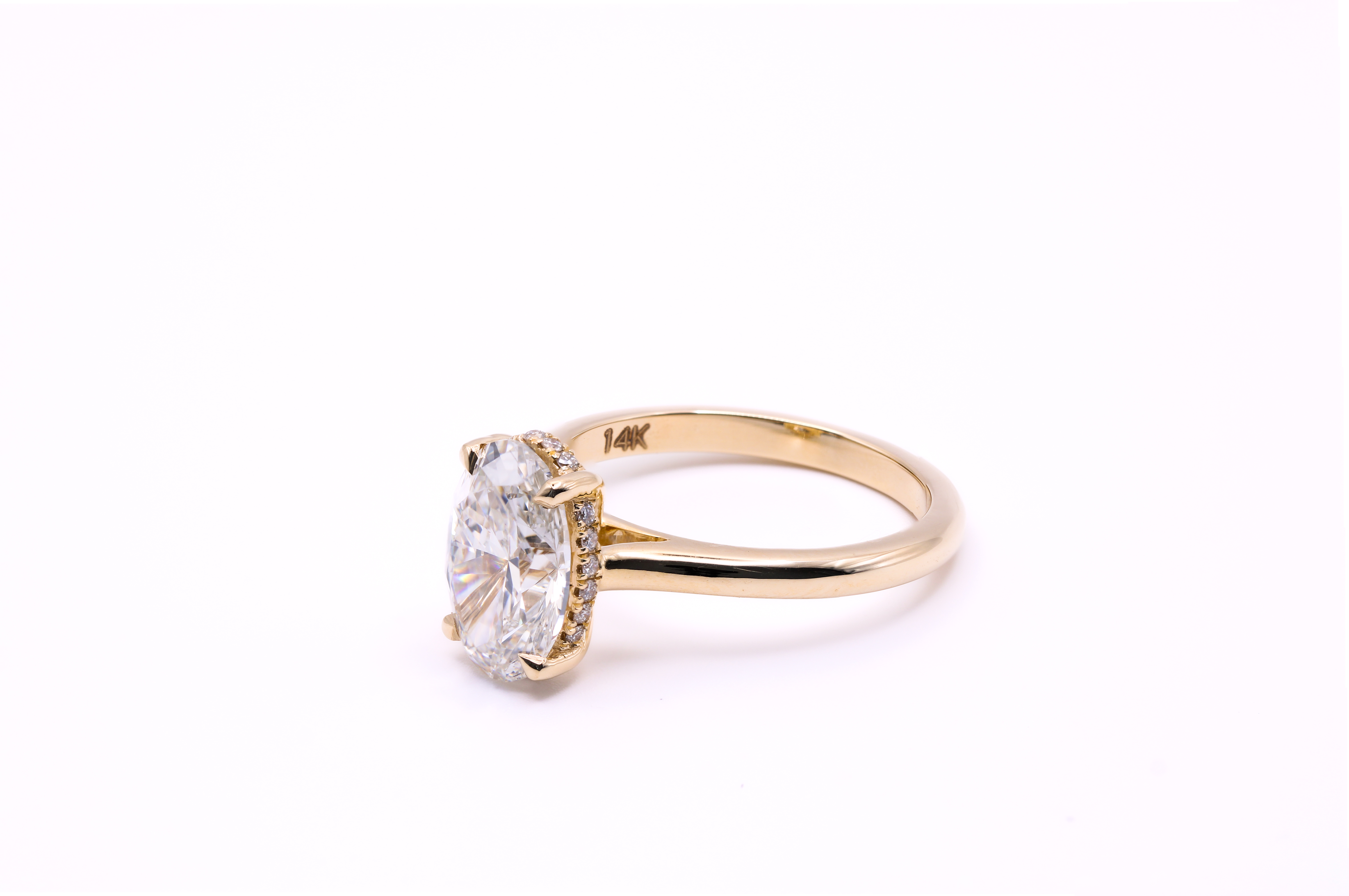 Oval hidden halo engagement ring side view